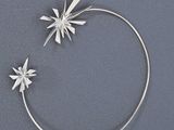 a close up of a silver bracelet with a flower on it