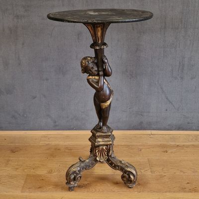 une statue antique en bronze représentant une femme tenant un vase, posée sur un socle