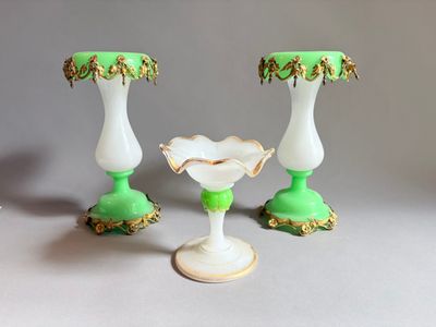 trois vases verts et blancs posés sur une table
