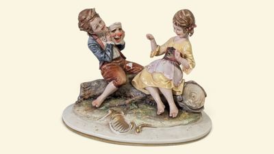 une figurine représentant deux enfants assis sur un rocher