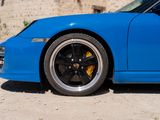 a blue sports car parked in front of a stone wall