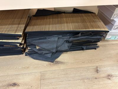 a lot of folded up black pants on the floor