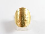 une image représentant une bague en or sur laquelle figure le visage d'une femme