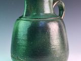 a green vase that is sitting on a table