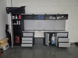 a garage with a work bench and cabinets in it
