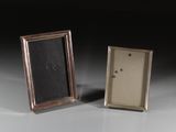 une paire de cadres photo anciens en argent posés sur une surface blanche