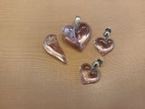 four pieces of heart shaped glass sitting on top of a table