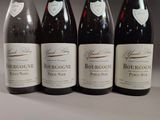 four bottles of wine are lined up on a table