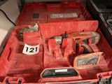 une boîte à outils rouge contenant des outils, posée sur une étagère