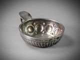 a silver bowl with a spoon in it sitting on a table