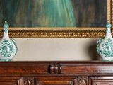 deux vases posés sur le dessus d'un meuble, devant un tableau