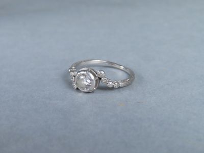 a close up of a diamond ring on a blue surface