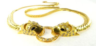 une image représentant un collier en or orné de deux chats