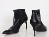 pair of black leather ankle boots with zippers on a white surface