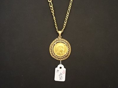 une pièce d'or à laquelle est attachée une étiquette au bout d'une chaîne