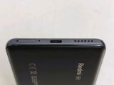 the back of a black cell phone sitting on top of a table