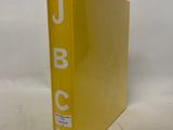 yellow binder with white letters on it sitting on a white surface