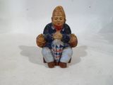 une figurine représentant un homme assis par terre