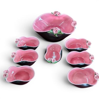pink and black ceramic bowls and spoons with pink flowers on them
