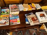 many books on a table with a couch in the background