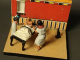 two figurines of a man and a woman sitting at a table