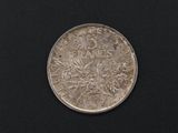 a close up of a silver coin on a black surface
