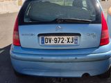 une petite voiture bleue garée sur le bord de la route