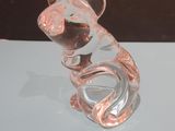 a glass figurine of a mouse sitting on top of a table