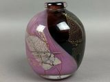 a purple vase with a black and gold design on it