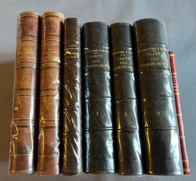 six vieux livres sont alignés sur une surface blanche