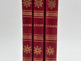 two red books sitting on top of each other on a white surface