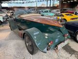 cars parked in a garage with a surfboard on the back of the car