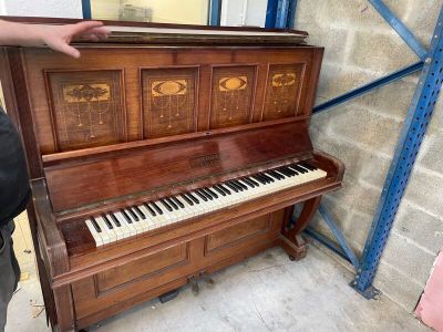 un homme debout à côté d'un piano dans une pièce