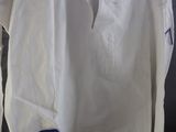 a white shirt hanging on a hanger on the wall