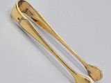 a pair of gold plated spoons on a white surface