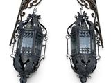 pair of ornate iron wall sconces with glass panels
