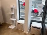 a room with a window, shelves, and a bike in the background