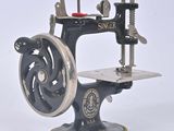 a black and silver sewing machine on a white surface