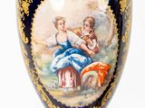 a vase with a painting on it sitting on a table