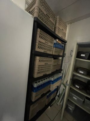 un réfrigérateur dans une pièce où les étagères sont encombrées de cartons