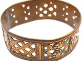 une image montrant un gros plan d'un bracelet en métal sur fond blanc