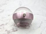 a glass ball with a pink band around it
