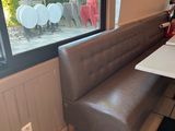a bench and a table in the corner of a restaurant