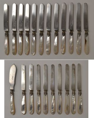 a set of six silverplated knives and a knife on a table