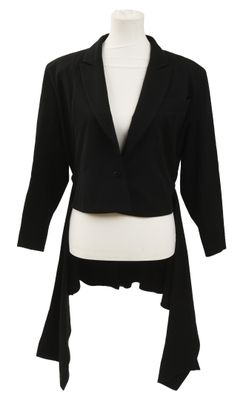 La veste est noire et on porte un haut blanc en dessous.