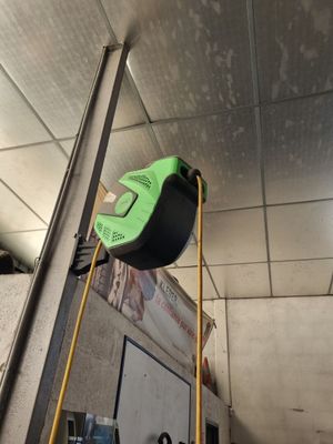 une photo d'un mètre ruban vert et noir fixé à un poteau métallique