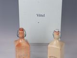 two bottles of perfume sitting next to each other on a table