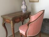 a chair and a table in a room with pictures on the wall