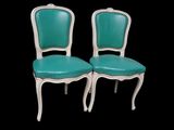 pair of turquoise leather chairs with white frame and wood legs