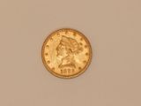 a close up of a gold coin on a white surface
